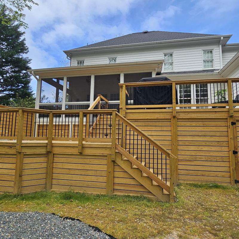 Wooden backyard deck with stair railing and privacy panels