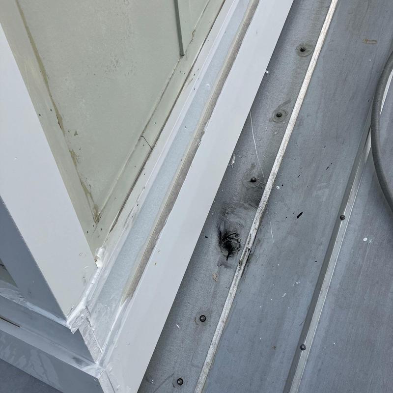 Metal roof seam with sealed leak near window base