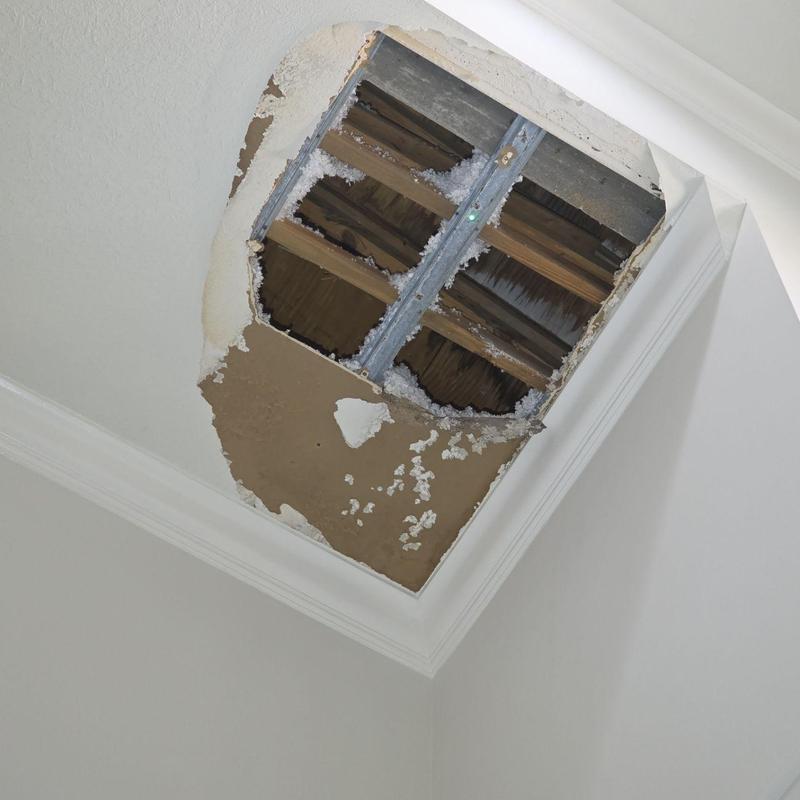 Drywall ceiling damage with insulation exposure