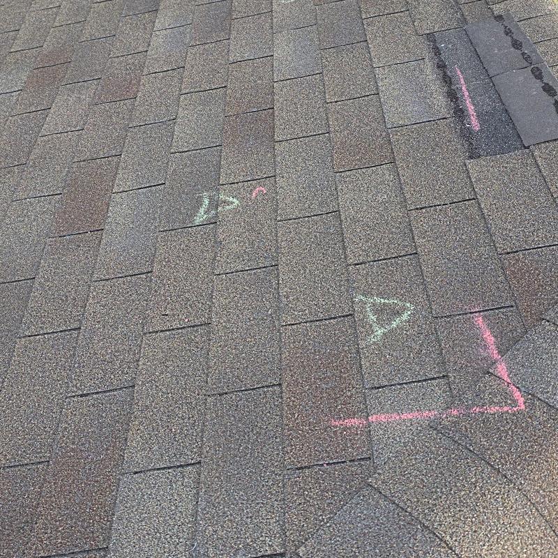Asphalt roof shingles with hail damage markings
