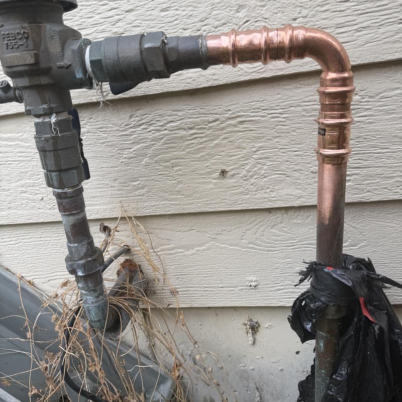 Split elbow on copper vacuum breaker pipe outdoors