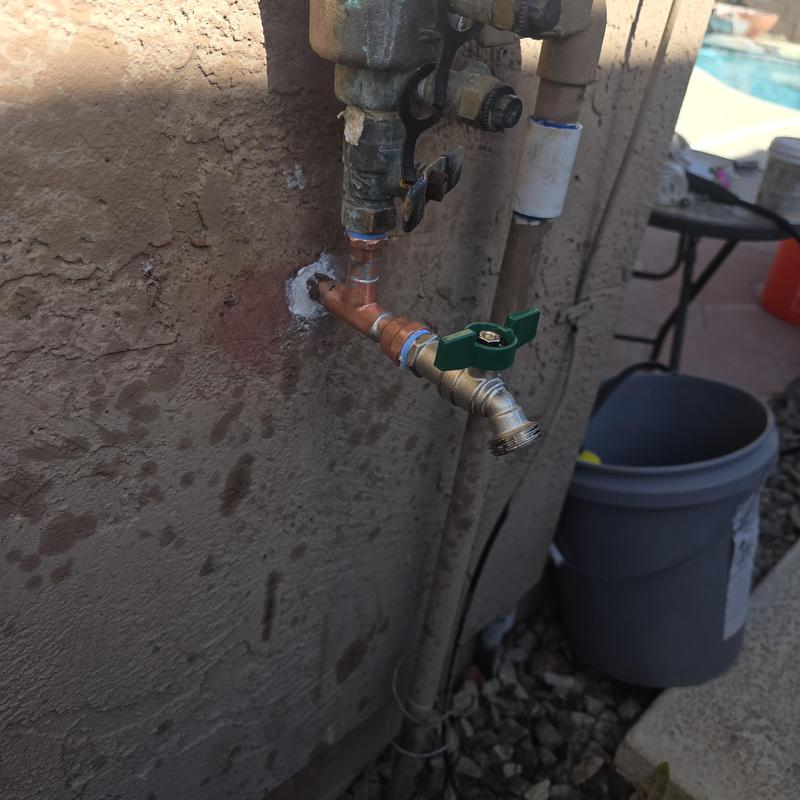 Backyard hose bib with green handle valve and tee