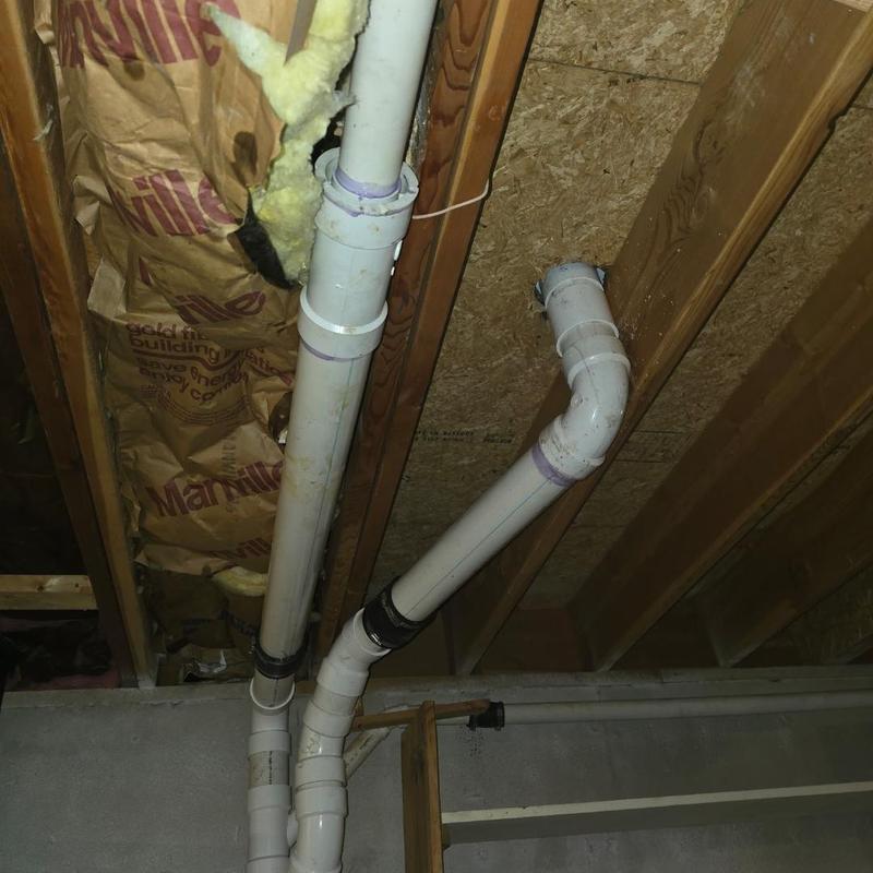 PVC sewer line with new flange installation in basement ceiling