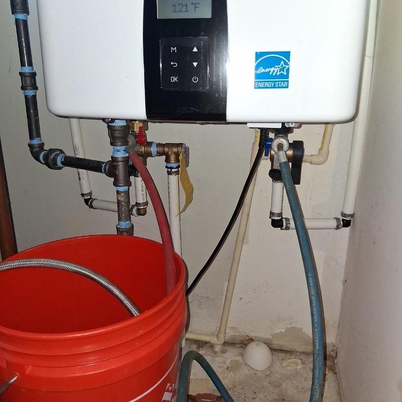 Tankless water heater with cleaning hoses and bucket