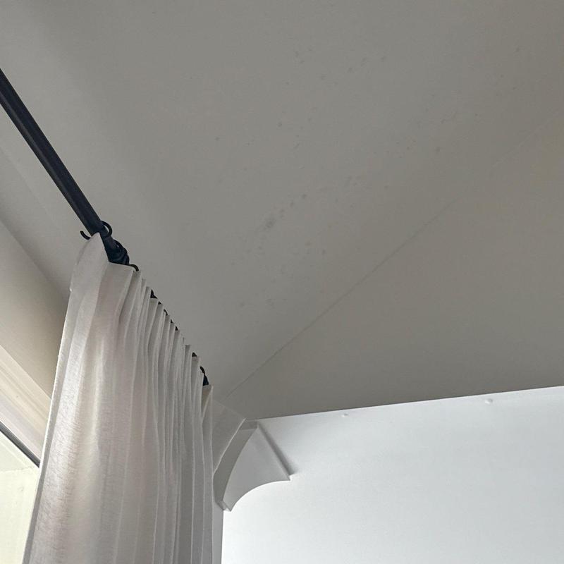 Ceiling water stains near window curtain rod