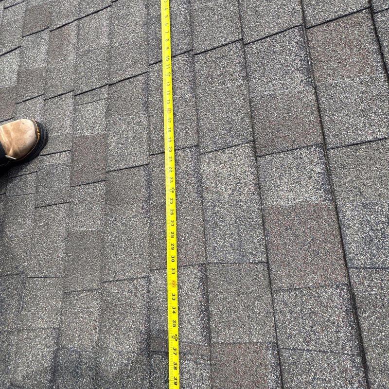 Asphalt shingles with measuring tape on roof inspection
