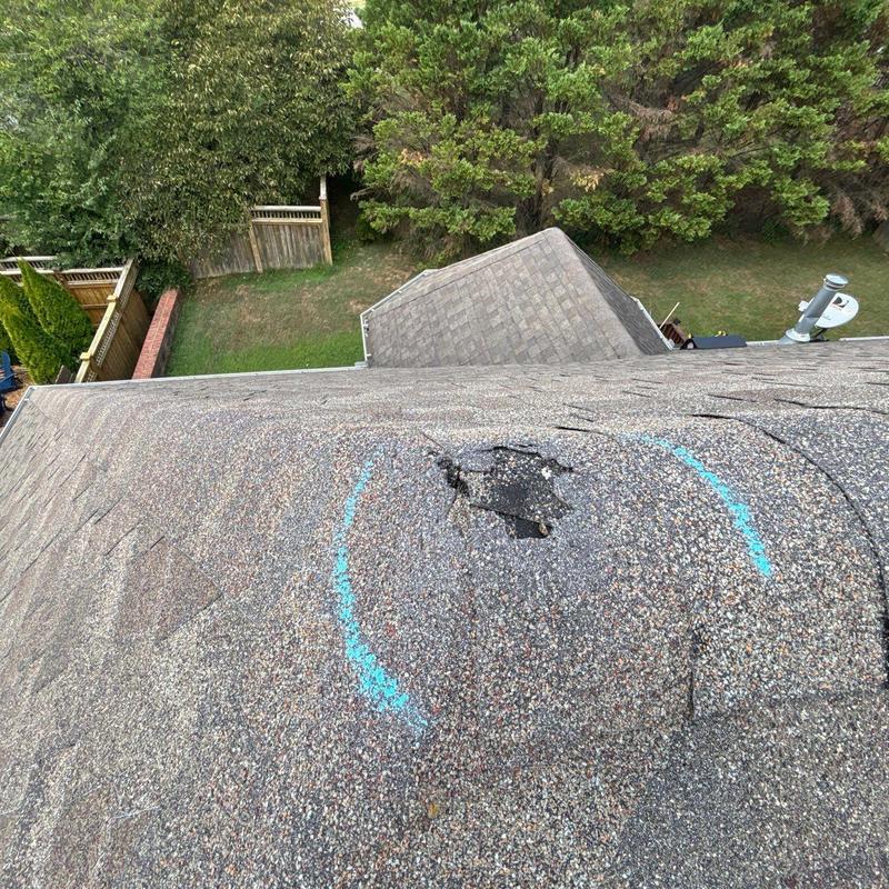 Roof shingles with hail damage marked for repair
