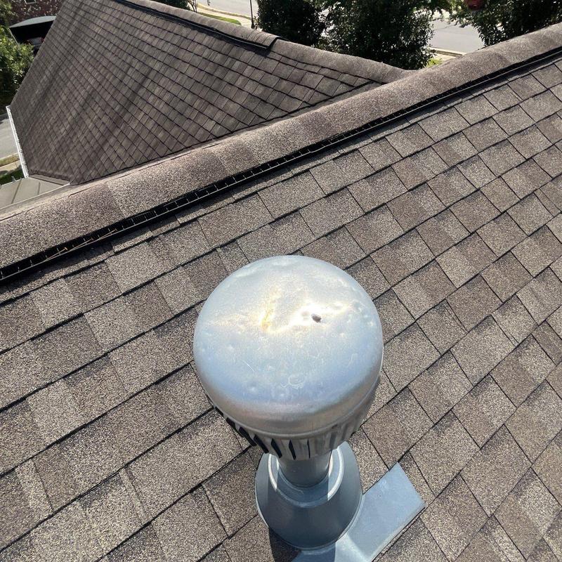 Metal roof vent pipe cap with hail damage on shingles
