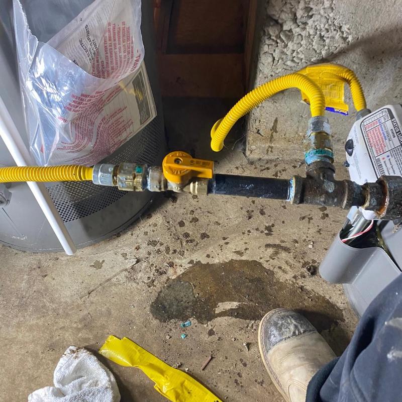 Gas control valves on water heater with yellow piping