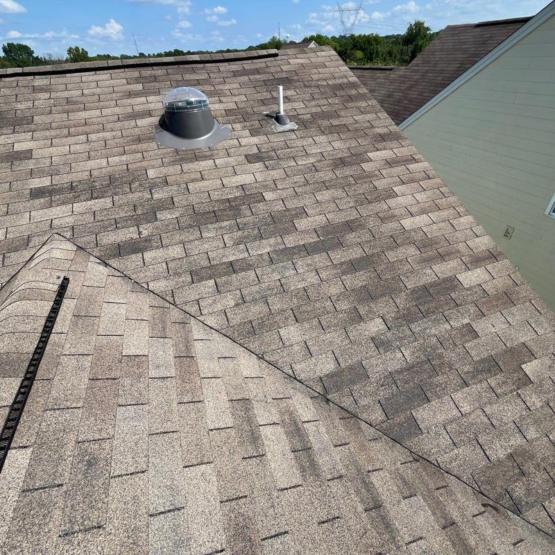 Roof shingles with visible hail damage and vents