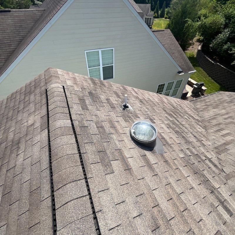 Asphalt shingle roof with skylight and ridge vent installation