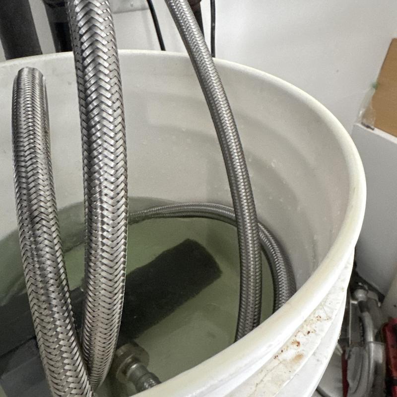 Rinnai tankless water heater flushing hoses in bucket