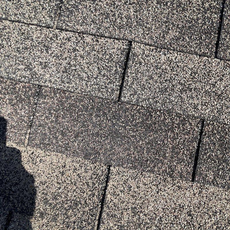 Asphalt shingles with hail damage on roof surface