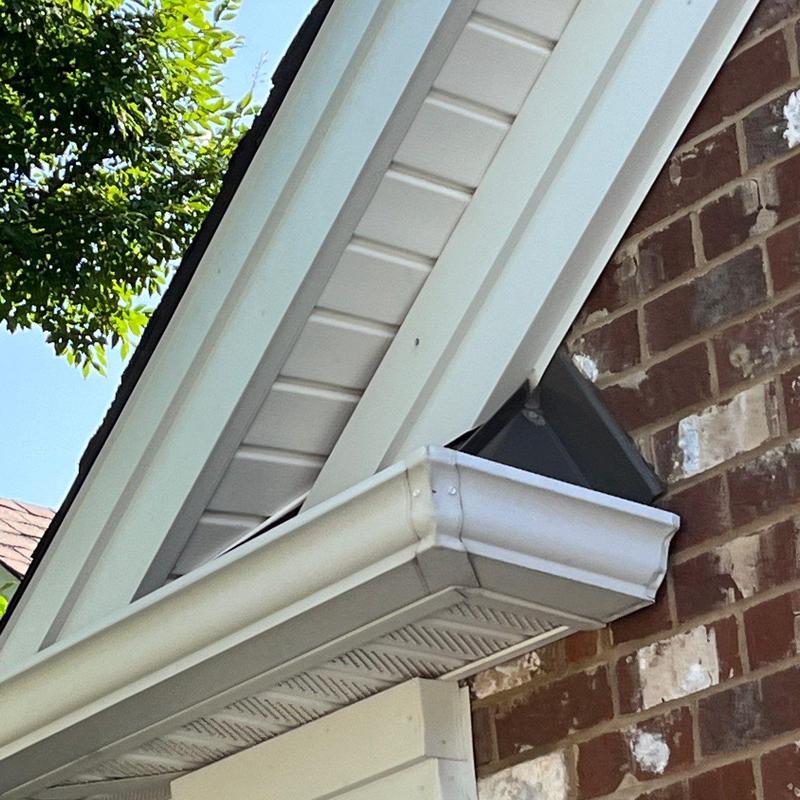 Gutter and soffit installation on brick house corner
