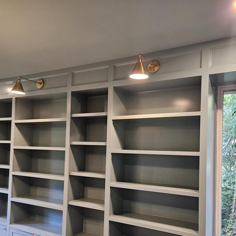 Built-in shelving with brass wall lights in closet Built-in shelving with brass wall lights in closet
