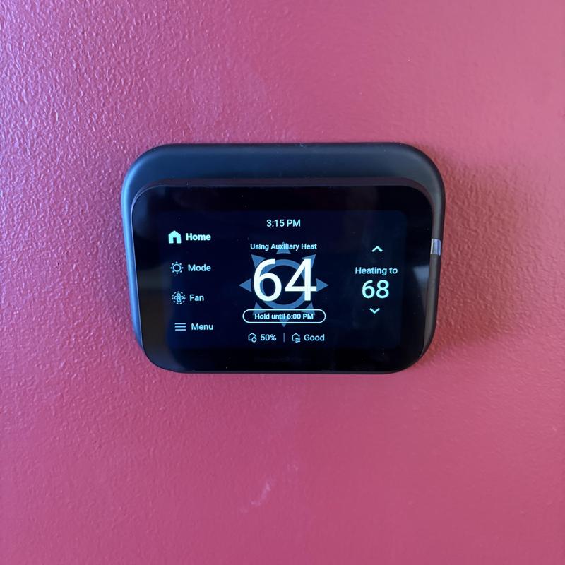 Smart thermostat display showing heating to 68°F Smart thermostat display showing heating to 68°F