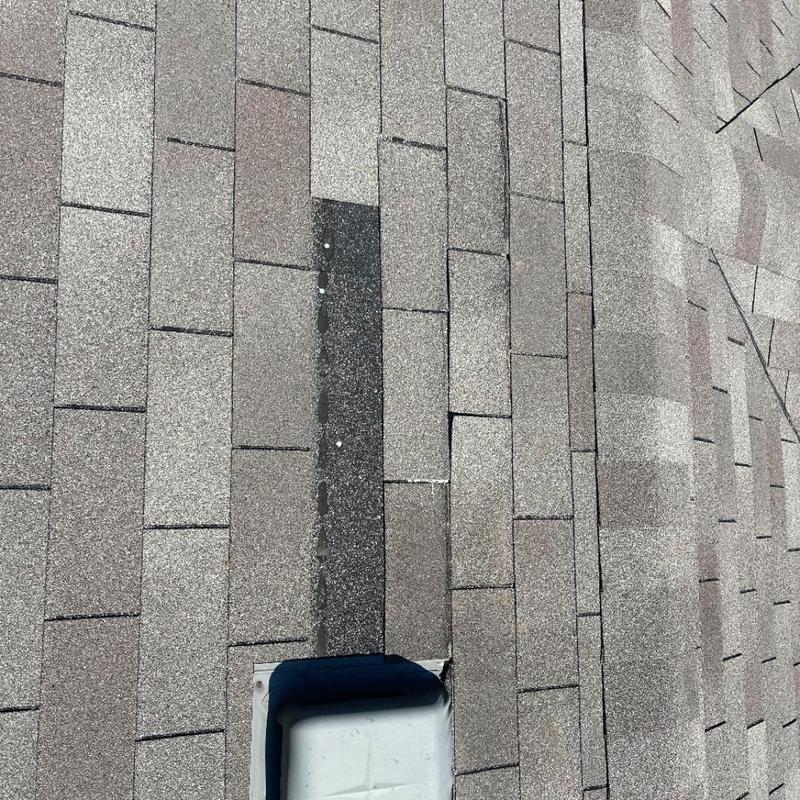 Asphalt roof shingles with hail damage around vent pipe