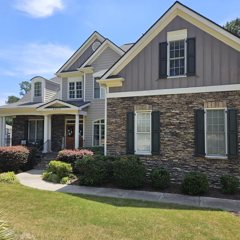 Exterior stone siding with windows and shutters