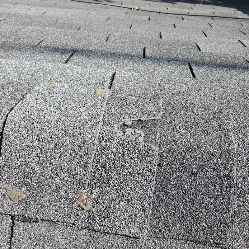 Asphalt roofing shingles with hail damage dents