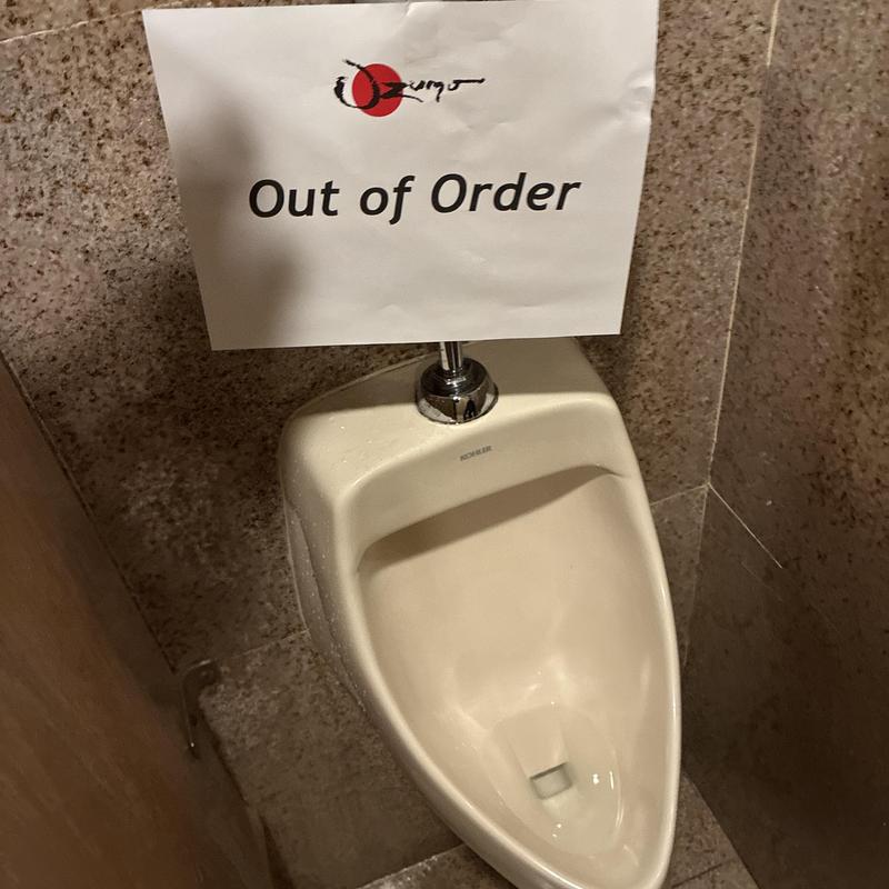 Sloan flushometer valve on urinal with out of order sign Sloan flushometer valve on urinal with out of order sign
