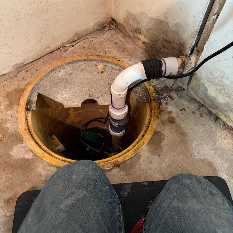 Sump pump system with discharge pipe in basement