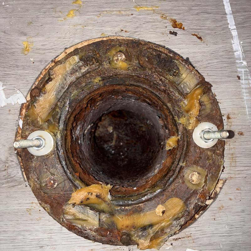 Toilet flange with rust and corrosion on floor surface Toilet flange with rust and corrosion on floor surface