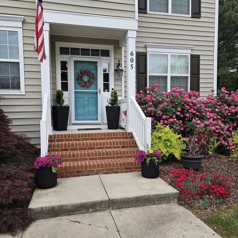 Brick front porch with white railing and blue door