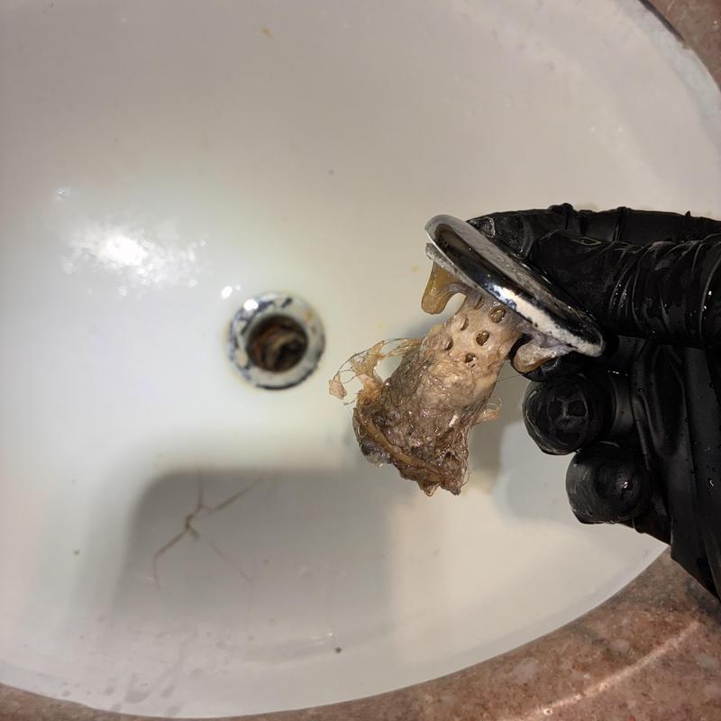 Basin sink pop-up drain assembly clogged with buildup