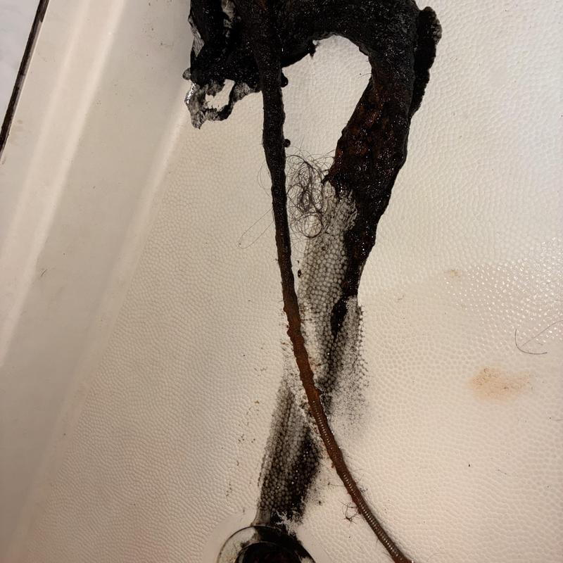Shower drain clog with removed hair and debris buildup