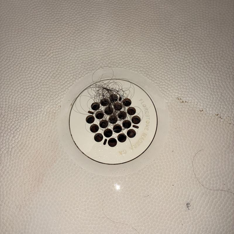 Shower drain with hair clog before cleaning