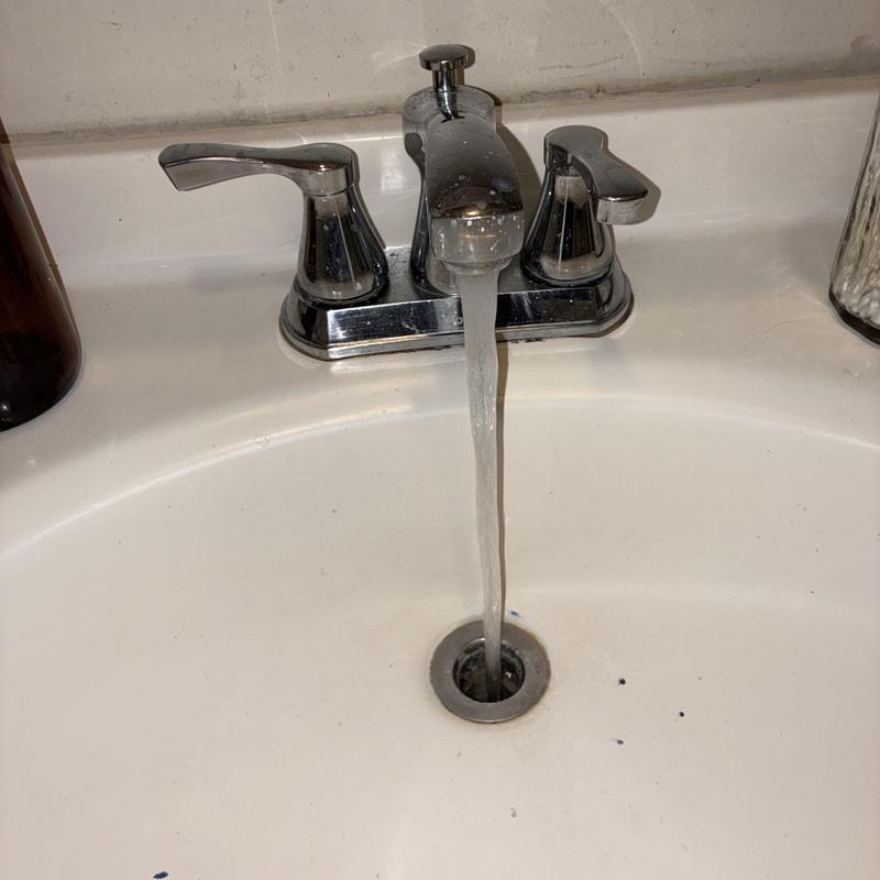 Bathroom sink drain cleaning with flowing water