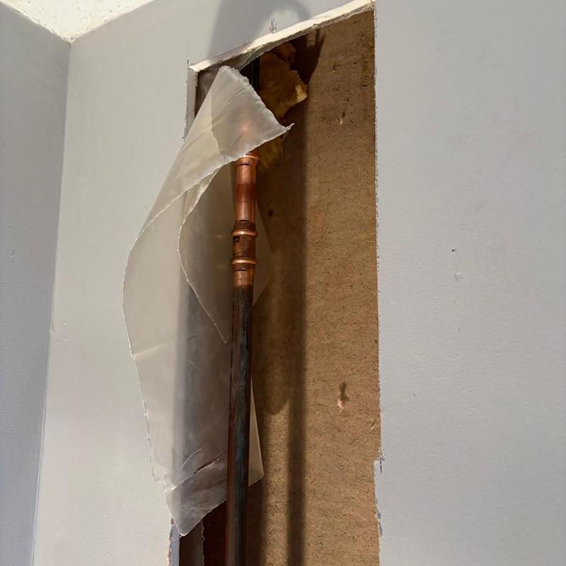 Copper pipe inside wall cavity with drywall removed