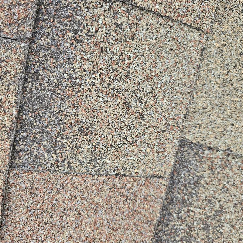 Asphalt shingle roof with hail damage close-up