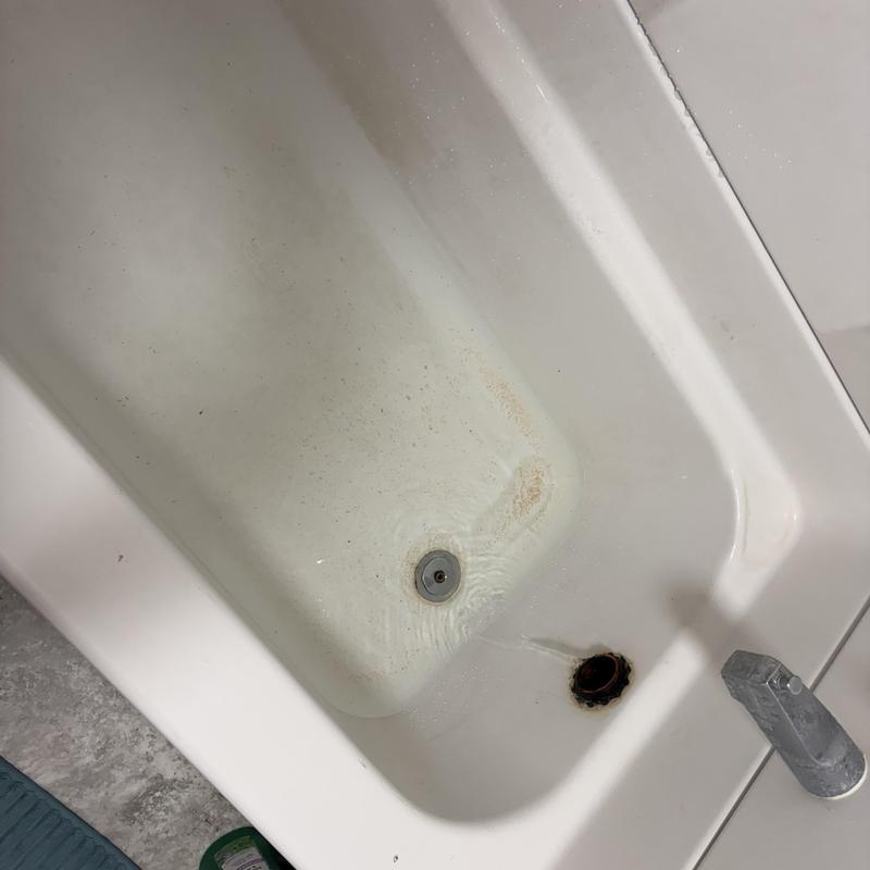 Bathtub drain showing water leak and discoloration