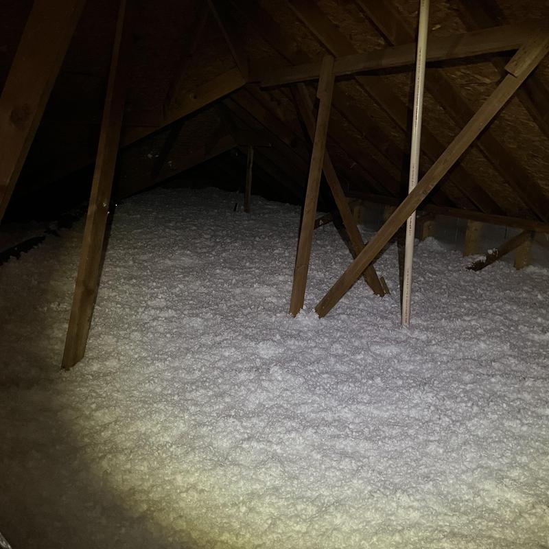 Attic loose-fill insulation installed under roof framing
