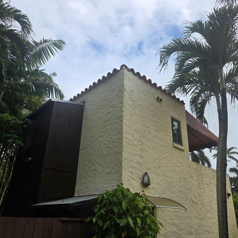 Spanish clay tile roof on residential building with palm trees