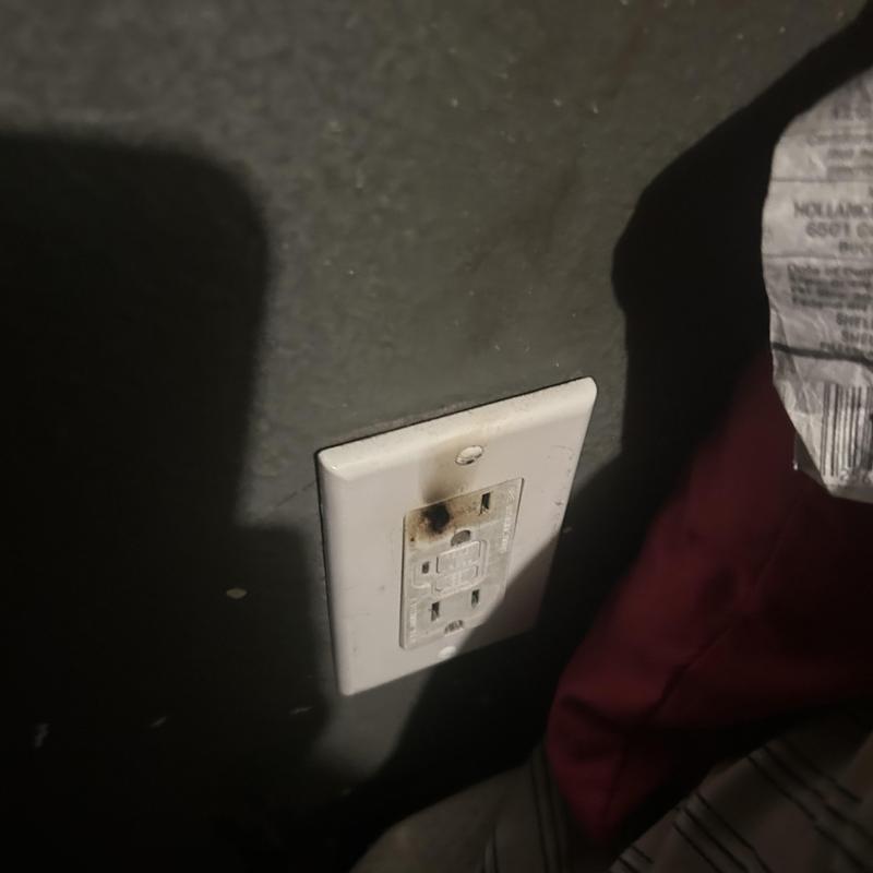 Burnt GFCI outlet on dark wall in home