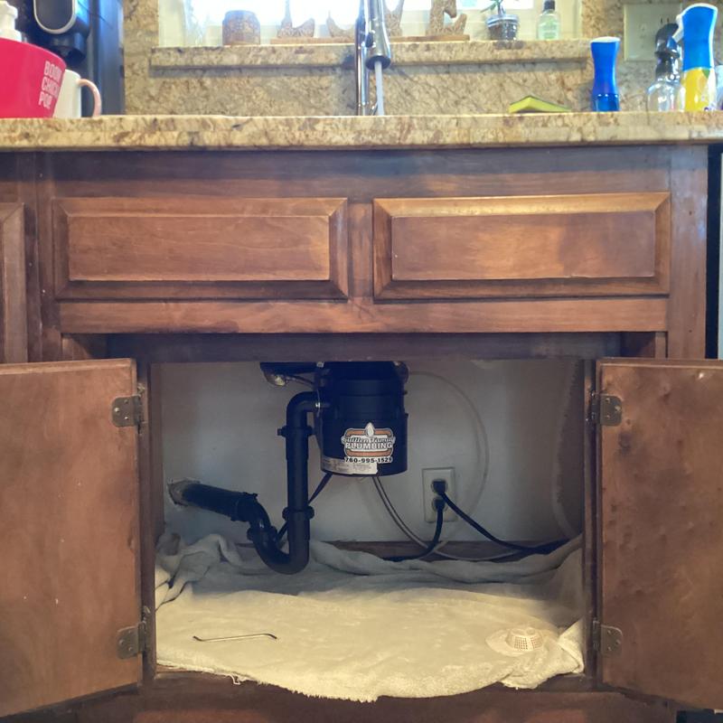 Garbage disposal and drain pipes under kitchen sink