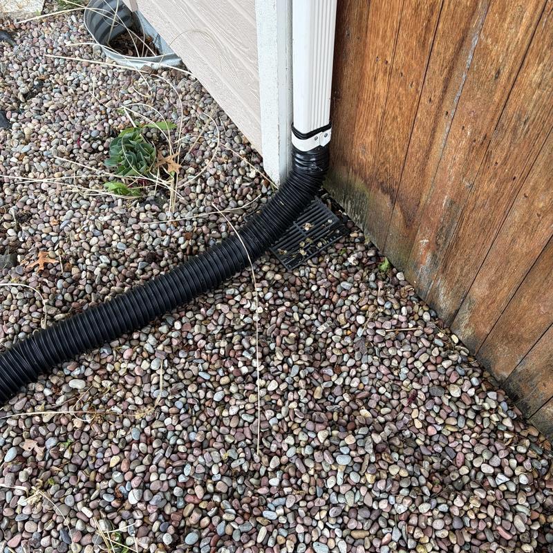 French drain system with downspout extension and gravel bed