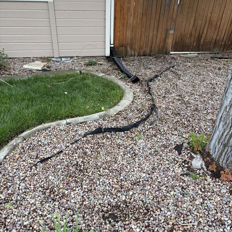 French drain with exposed and cracked liner outdoors