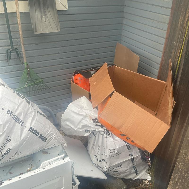 No specific system visible, outdoor storage area with tools and cardboard