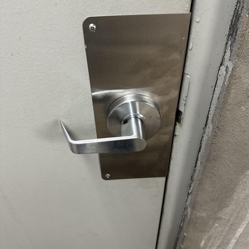 Door lever and metal wrap on parking garage door