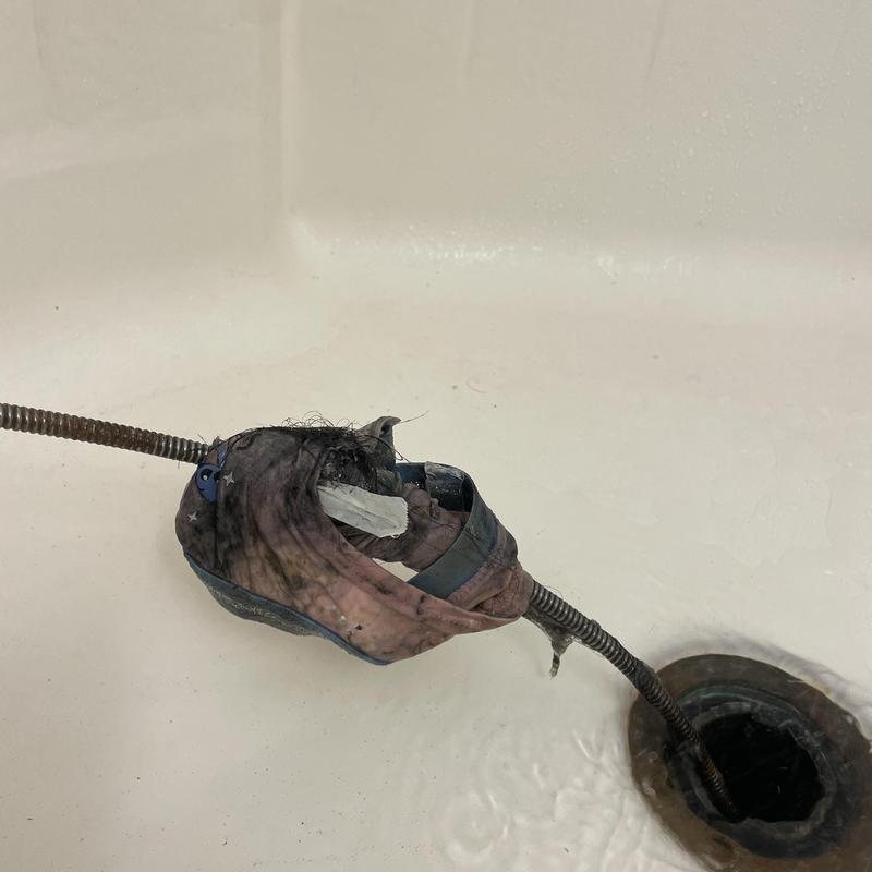 Shower drain clog with clothing removed by sewer snake