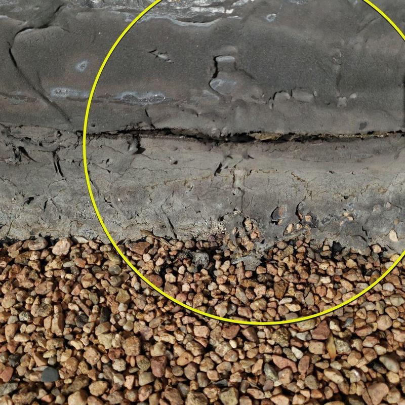 Tar and gravel roof cracked seam close-up with gravel