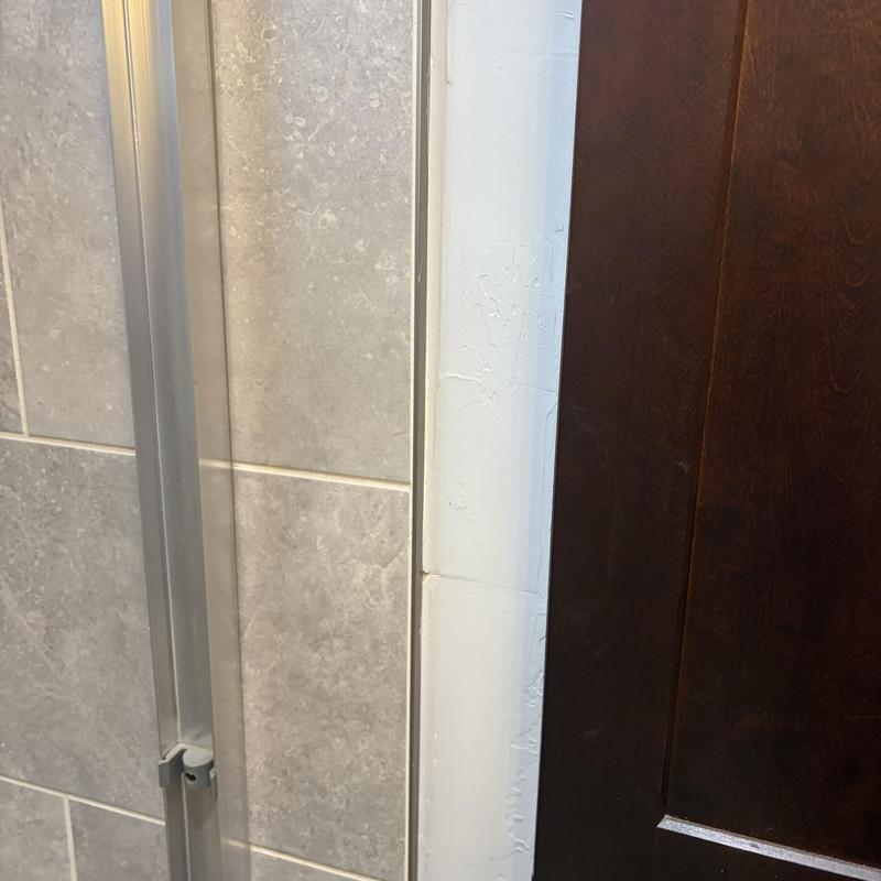 Walk-in tub door frame and tile wall close-up