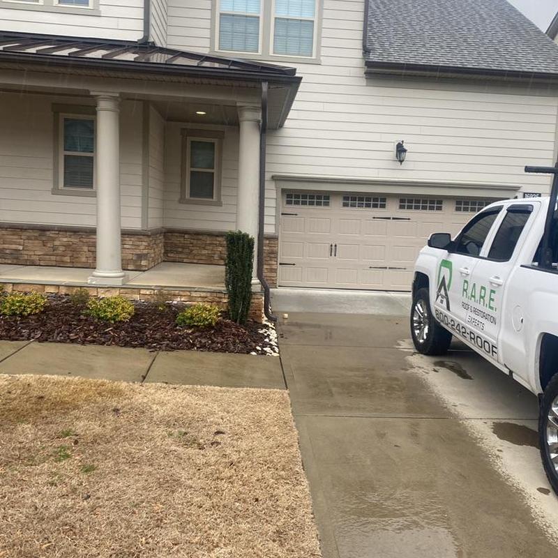 Gutter and downspout with repair truck nearby