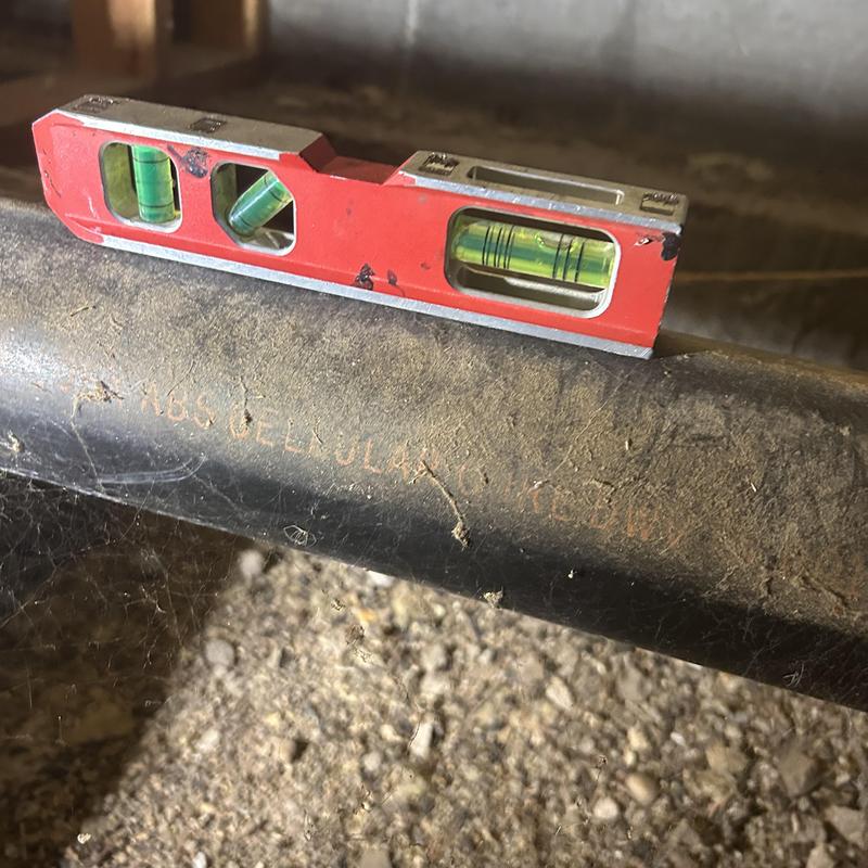 Building drain pipe with level tool on top