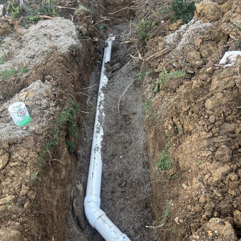 Sewer line with new PVC pipe in trench