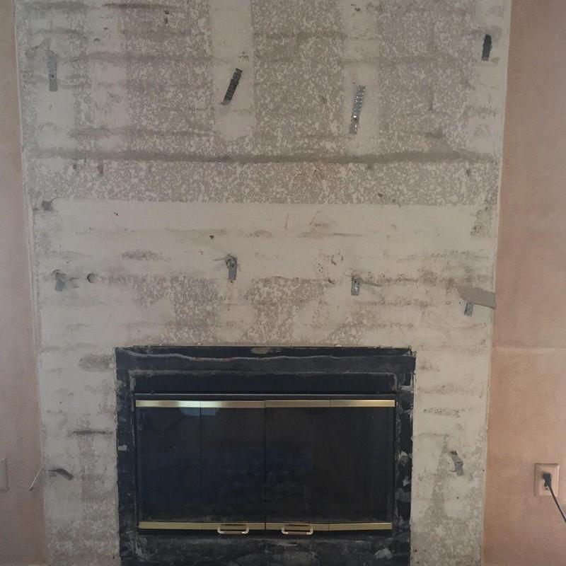 Fireplace glass insert with metal frame in stripped wall
