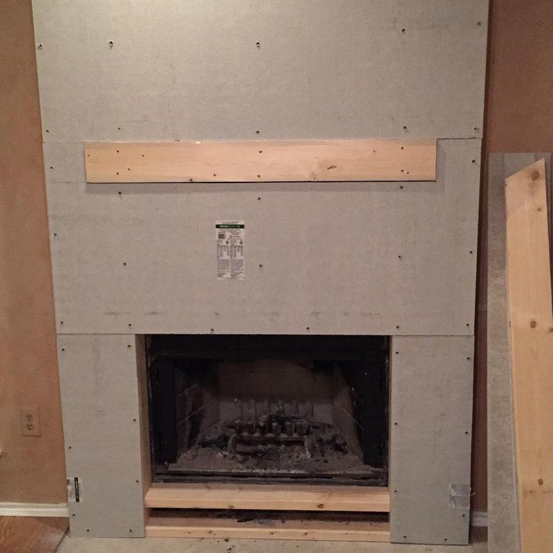 Fireplace stone surround framing with wooden mantel support